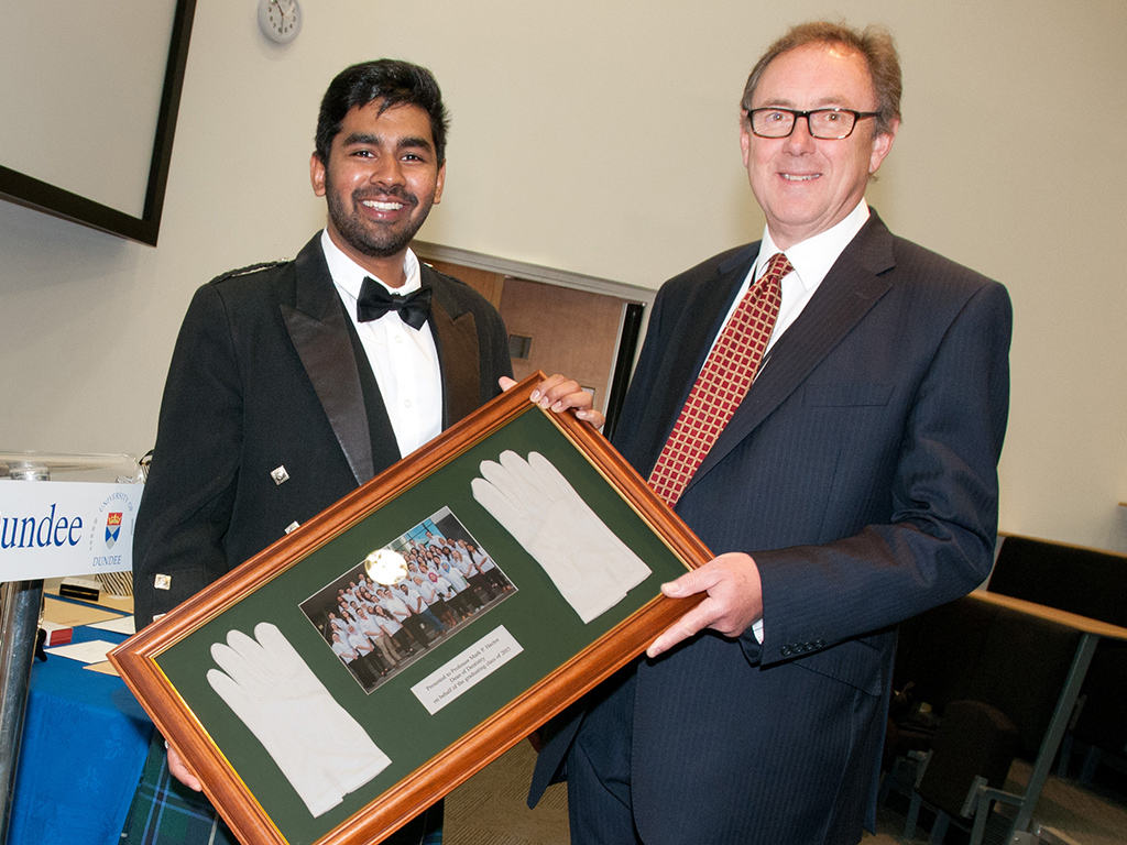 Presenting the white gloves to Prof Hector is 2015 graduate Nirmal Shah