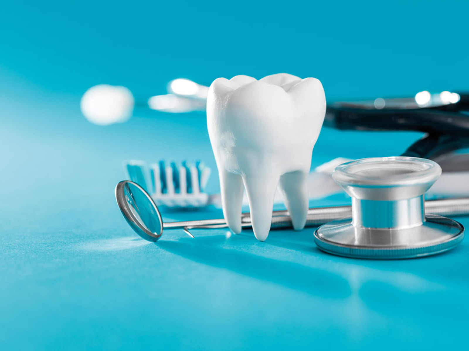 Dental tools surrounding a model of a tooth