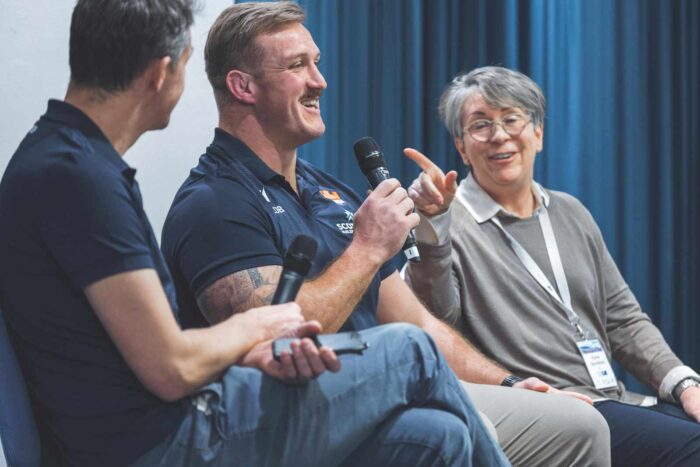 Mike Dunlop, Luan De Bruin and Fiona Davidson in a panel discussion. Luan holds a radio microphone.