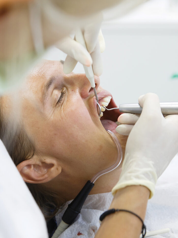 A dental hygienist checks a patients gums.
