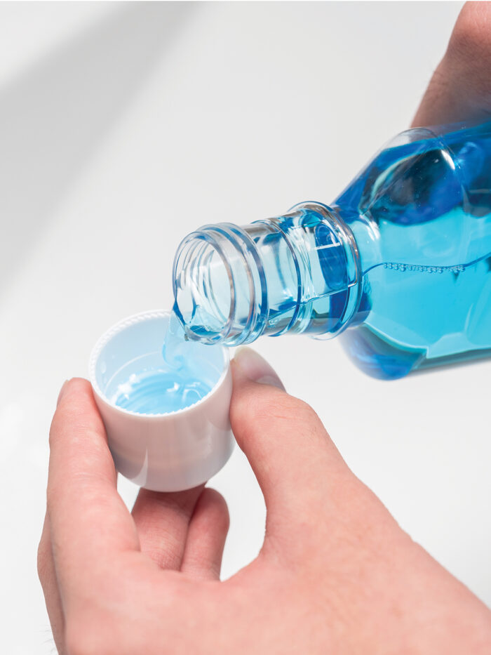 Mouthwash being measured out into the lid.